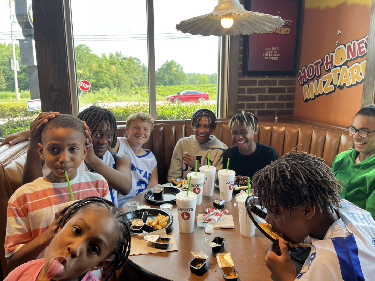 A group of kids enjoying a meal together at a restaurant table.