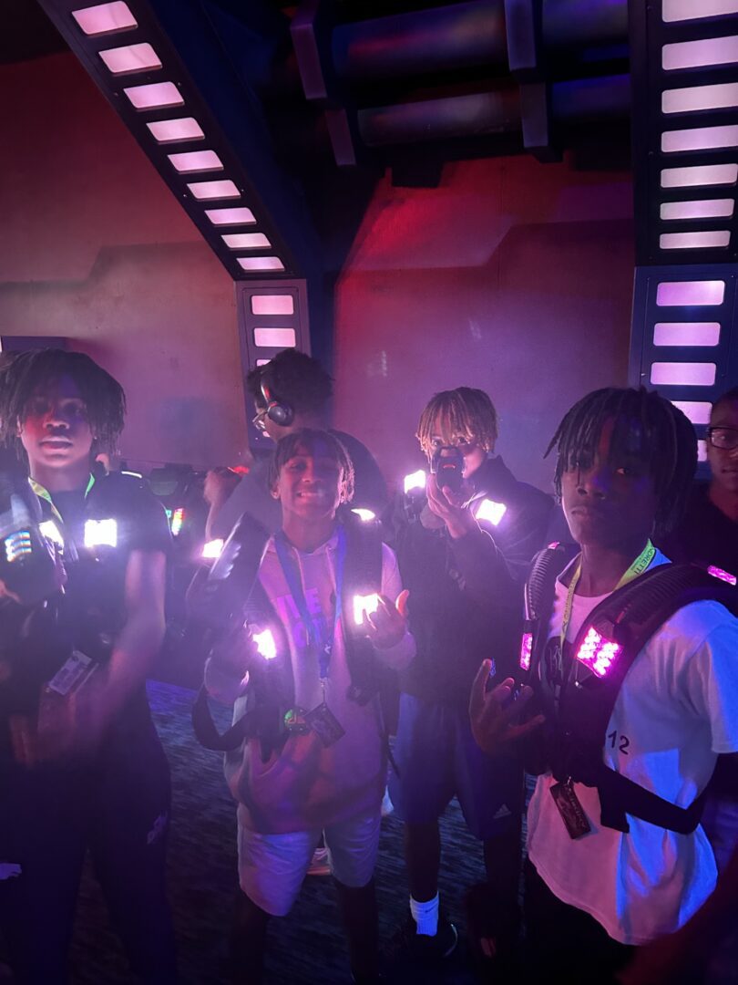 Group of friends glowing with vibrant LED lights in a dark setting.