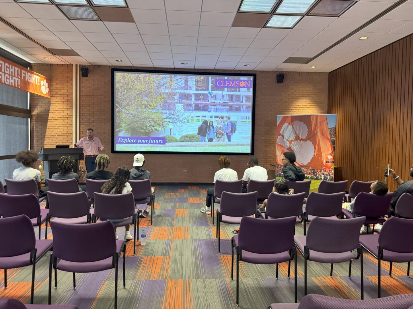 Audience watching a projected presentation in a conference room.