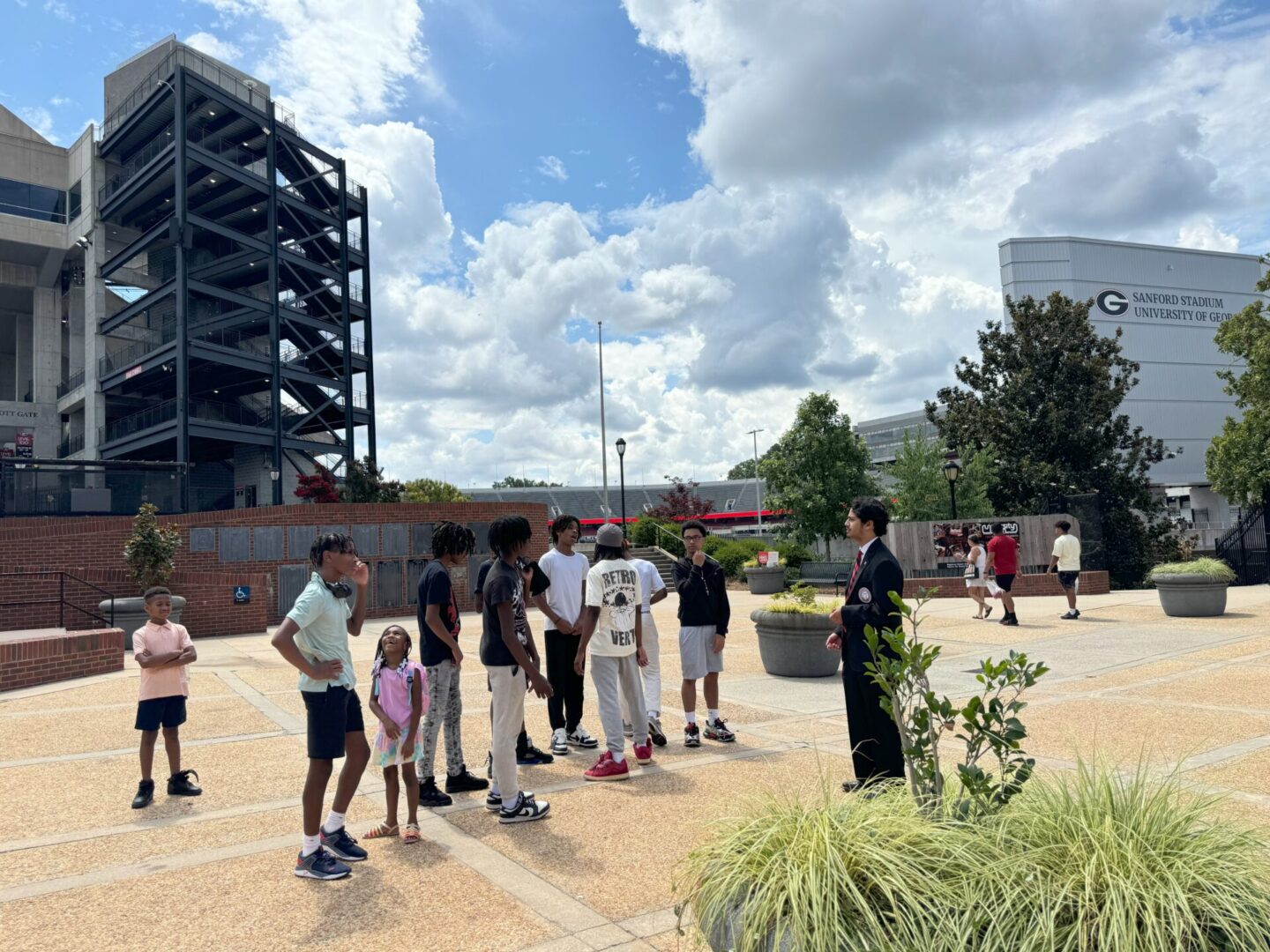 A group of people, including children, gathered outside on a cloudy day.
