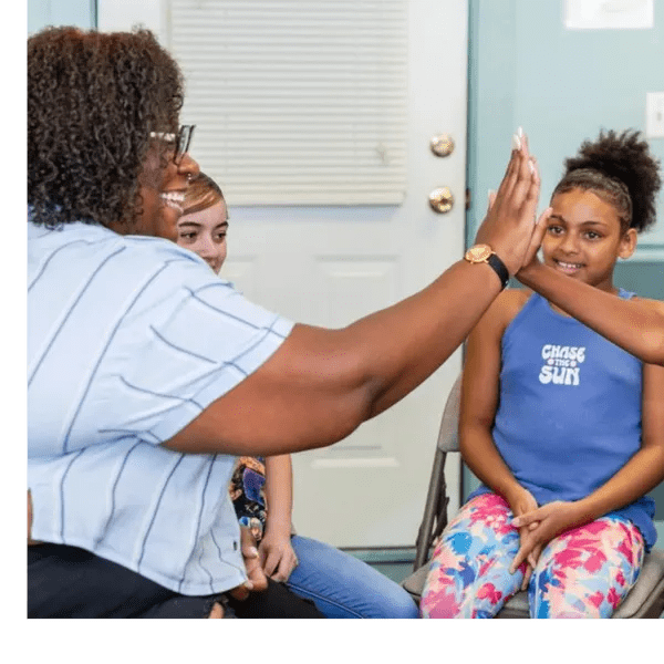 A woman and children hifiving